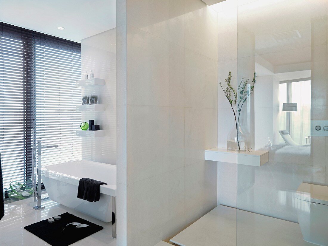 Elegant designer bathroom with a room partition between the vanity and toilet areas