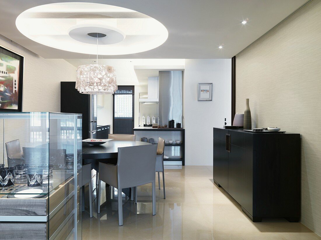 Dining area with designer lamp hanging from a recessed opening in a suspended ceiling in a modern living room