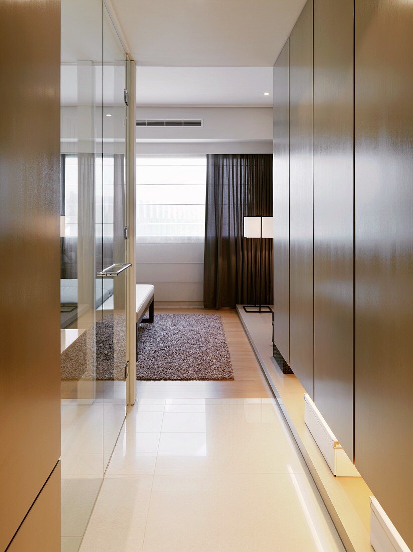 Hallway with modern built-in cupboards and view into an open bedroom