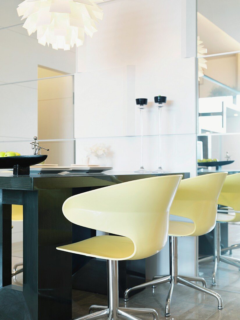 Helle Schalen-Drehstühle am Tisch aus dunklem Holz in modernem Ambiente