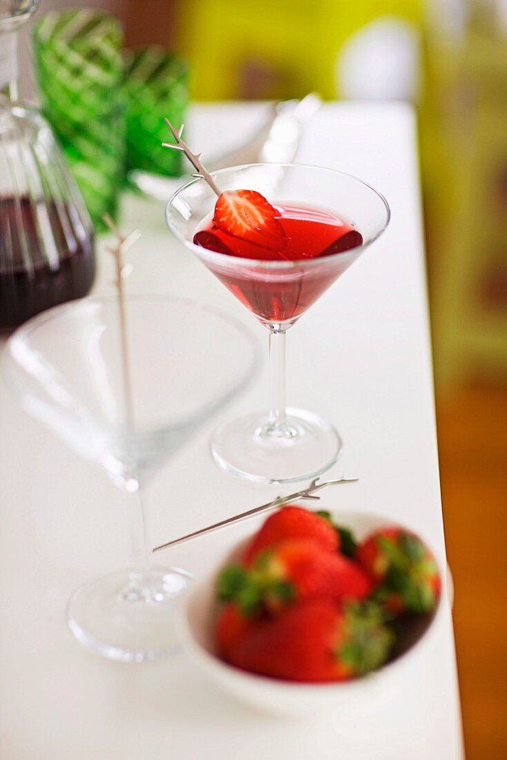 Ein Glas Erdbeer-Martini mit aufgespiesster Erdbeere