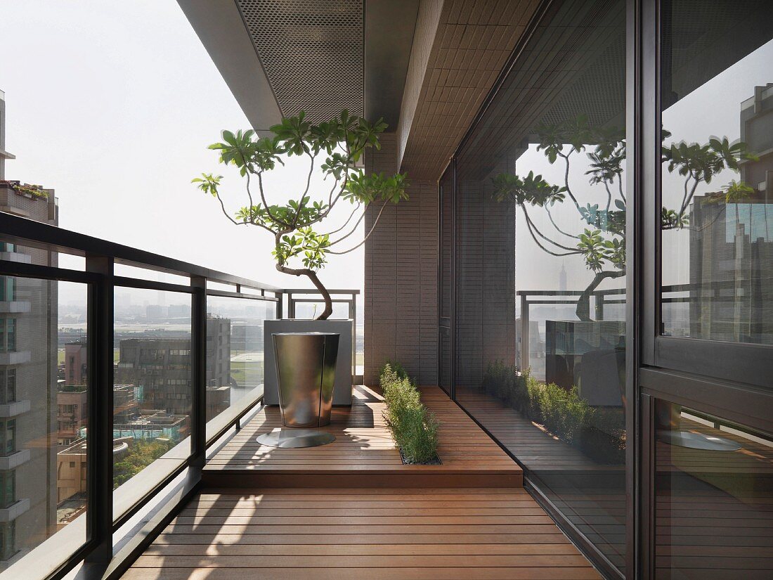 Bepflanzung auf dem Balkon eines modernen Hochhausappartements mit Blick über die Stadt