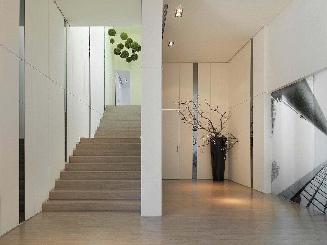 Minimalistisches Treppenhaus mit durch Glasstreifen in Felder aufgeteilten Wandpaneelen