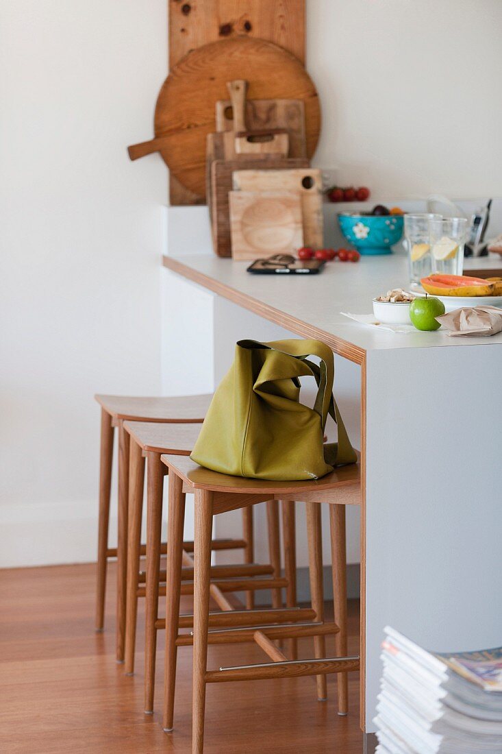 Green handbag on a narrow bar stool by a breakfast bar