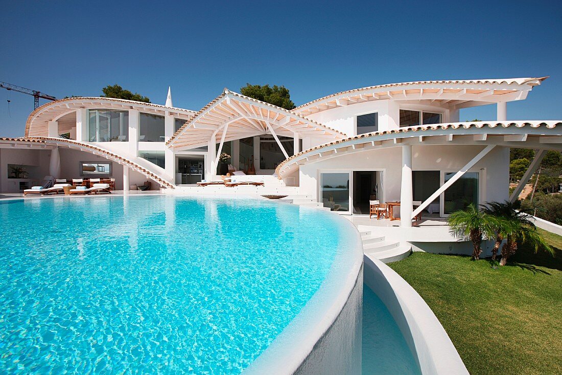 Swimmingpool einer spanischen Villa mit interessanter Dacharchitektur
