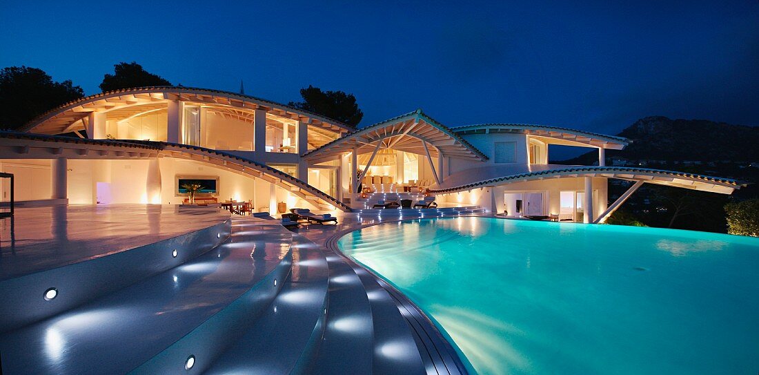 Die große Terrasse einer spanischen Villa mit beleuchteten Stufen und Pool