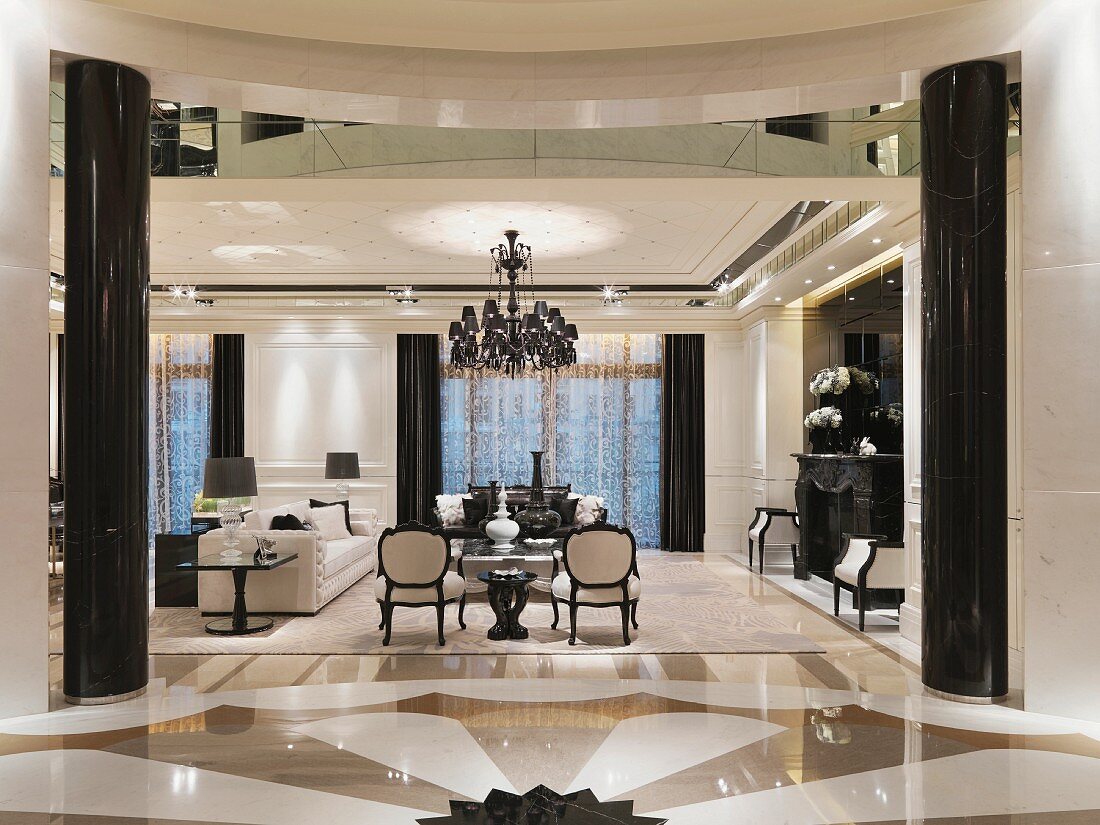 Grafisch gestalteter Marmorboden und schwarz glänzende Säulen als Auftakt in vornehmen Wohnbereich
