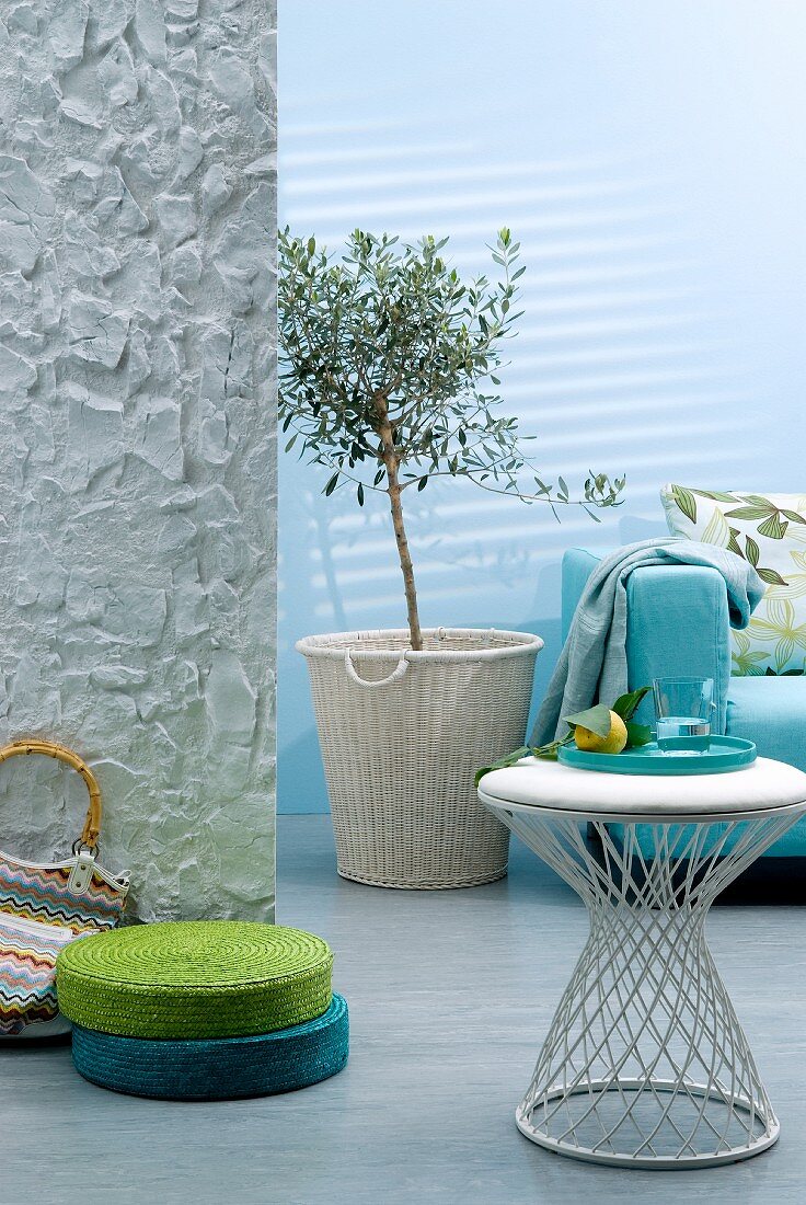Wohnraum in Aquafarben mit Sofa, Beistelltisch & Bodenpolster in Grün und Türkis