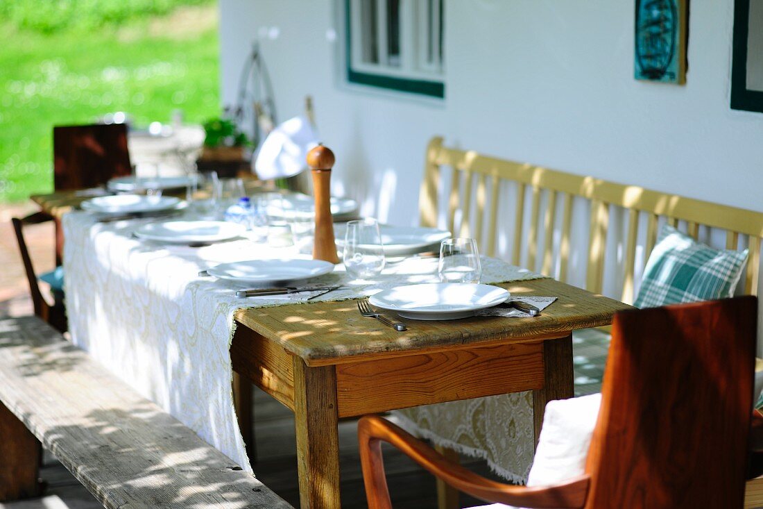 A set rustic table next to the wall of a house
