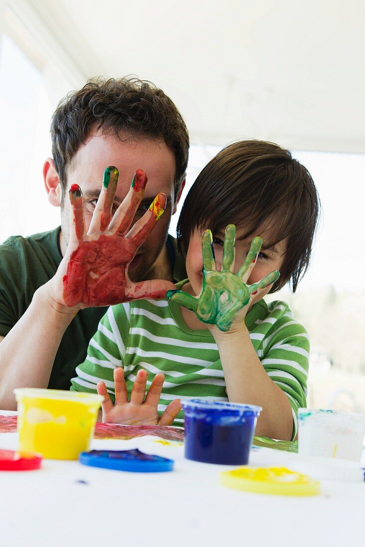 Vater und Sohn malen mit Fingerfarben