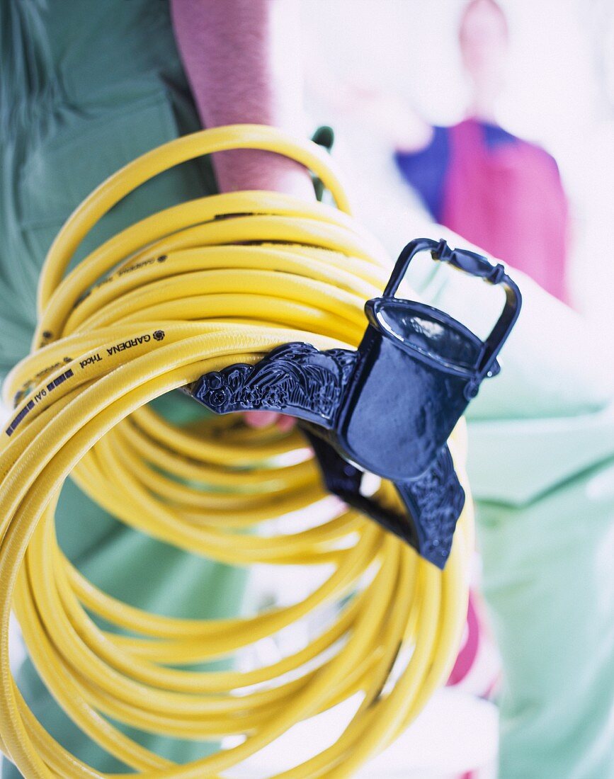 Yellow rubber hose wrapped around a hanger and held in a hand