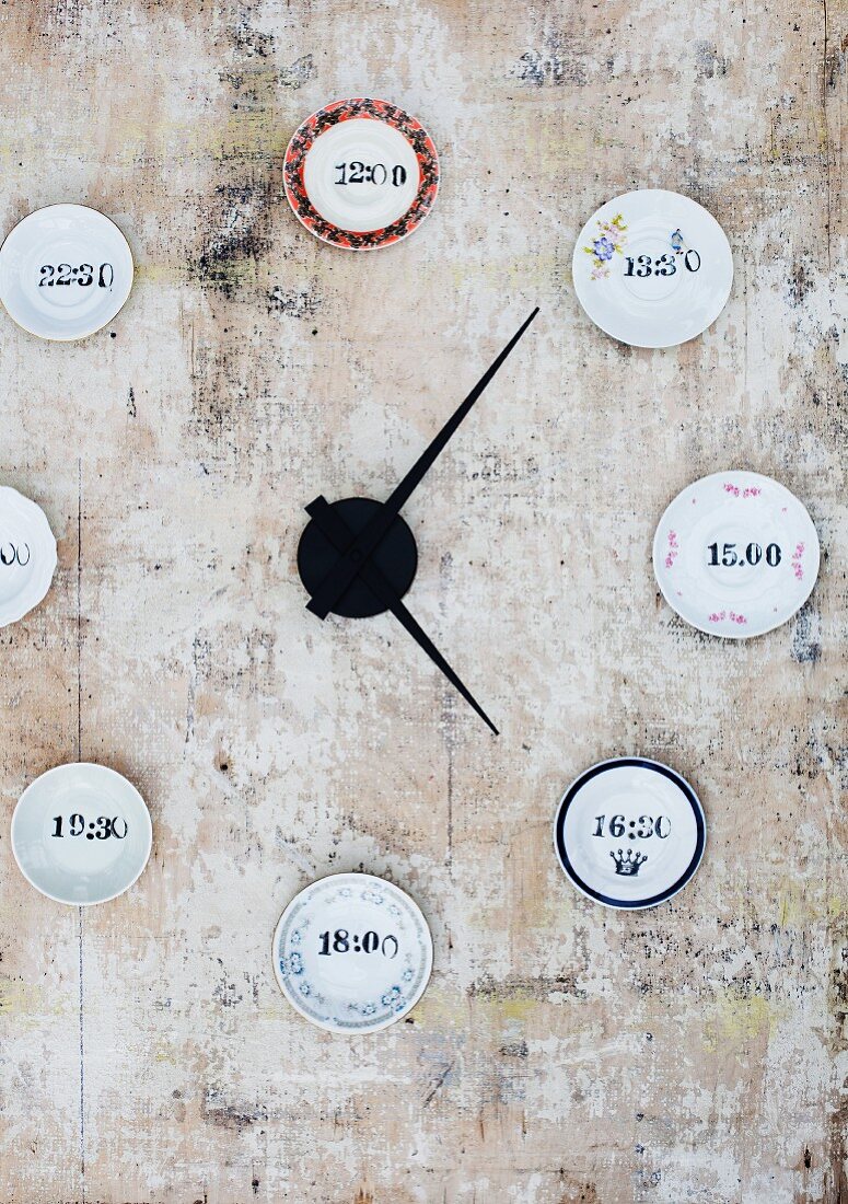 Wanduhr-Unikat mit gestempelten Uhrzeiten auf kleinen Tellern