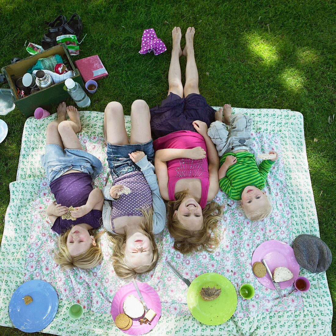 Kinder liegen auf der Picknickdecke