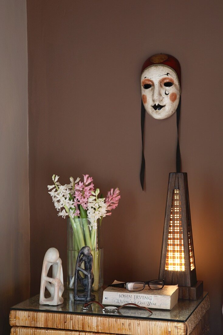 Hand bemalte venezianische Maske an brauner Wand über dem Nachttisch