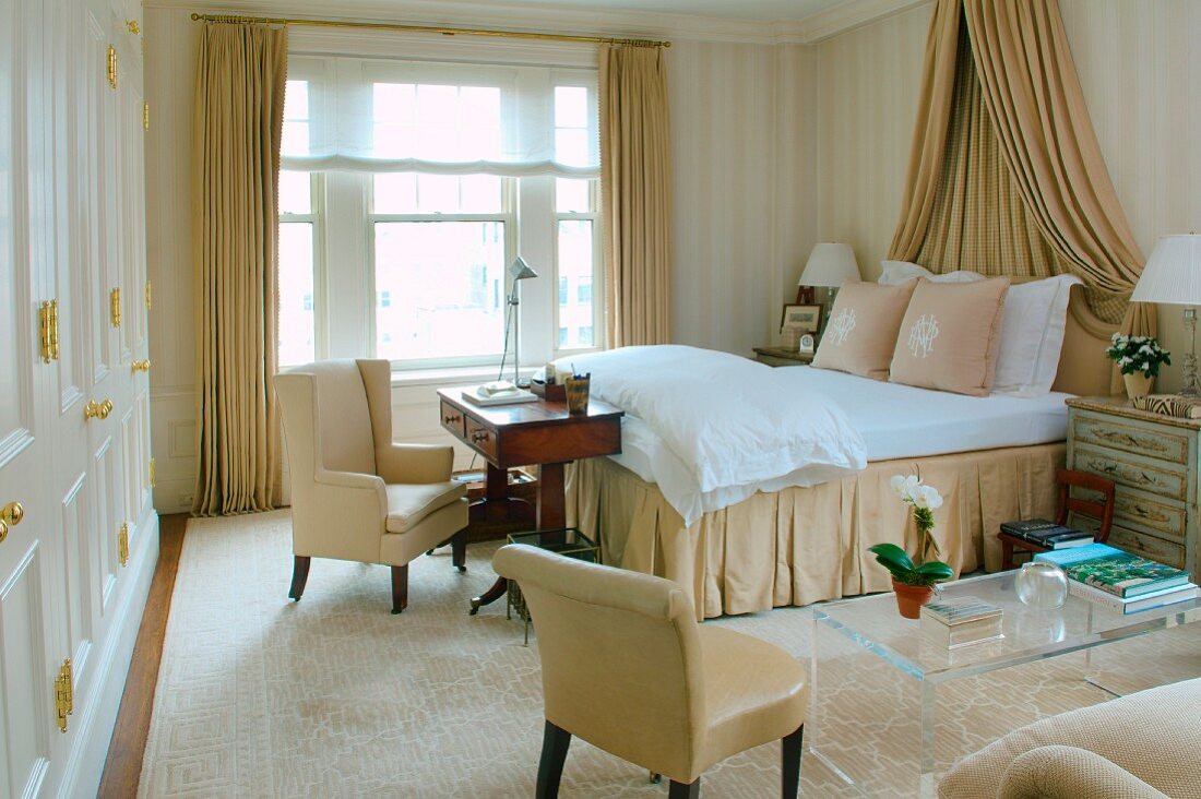 Klassische Eleganz in einem Schlafzimmer mit großem Baldachinbett und Stilmöbeln verschiedener Epochen