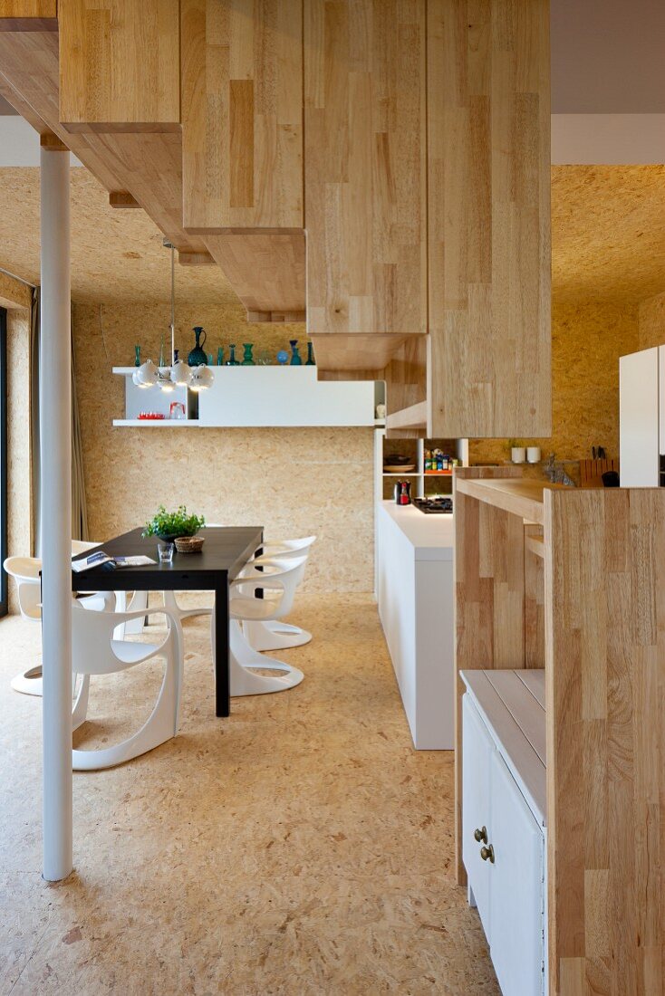 Treppe mit Holzverkleidung in offenem Wohnraum mit modernem Essplatz
