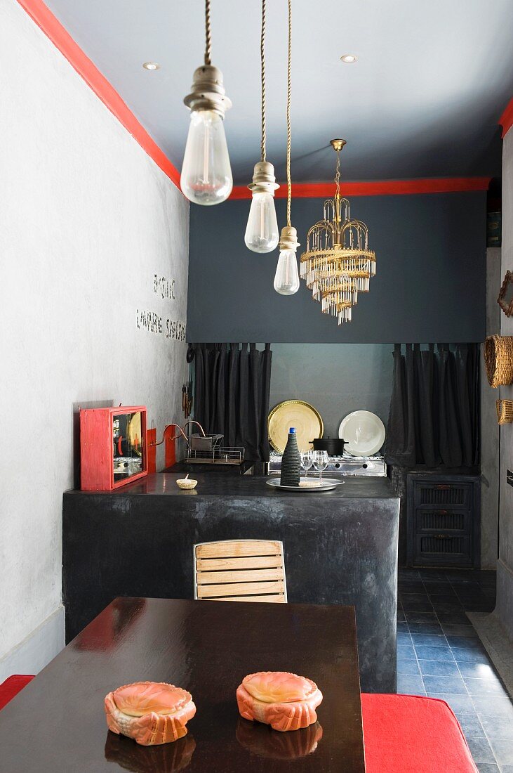 Minimalistische Küche in Schwarz und Grau mit roten Akzenten und Hängeleuchten in einer Reihe