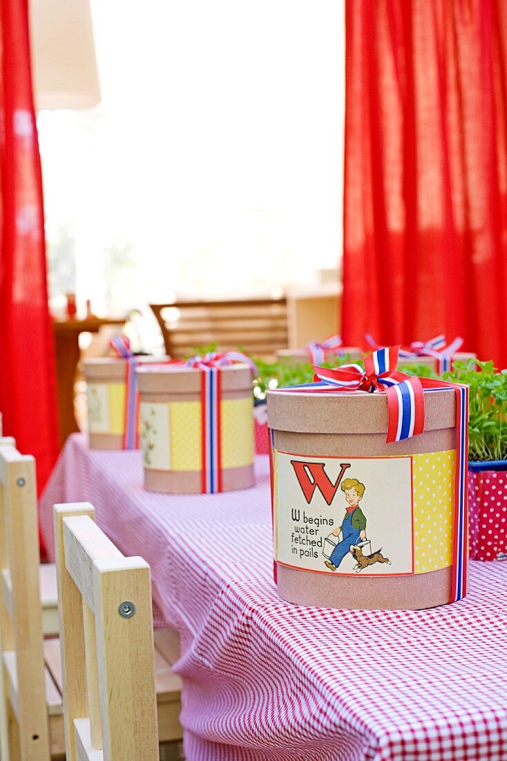 Beautifully packed boxes with large labels decorated with a child's theme on a children's table with checked tablecloth