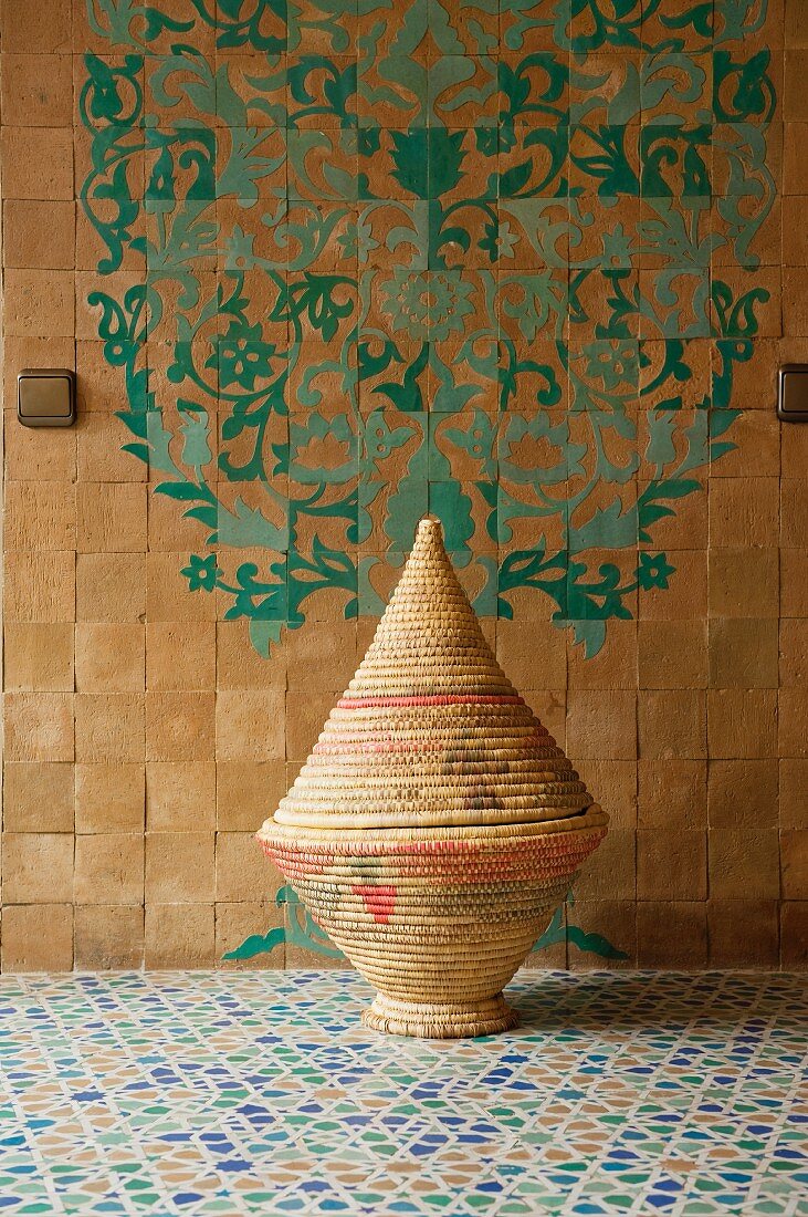 Woven basket in bathroom with a zellige floor and patterned wall tiles
