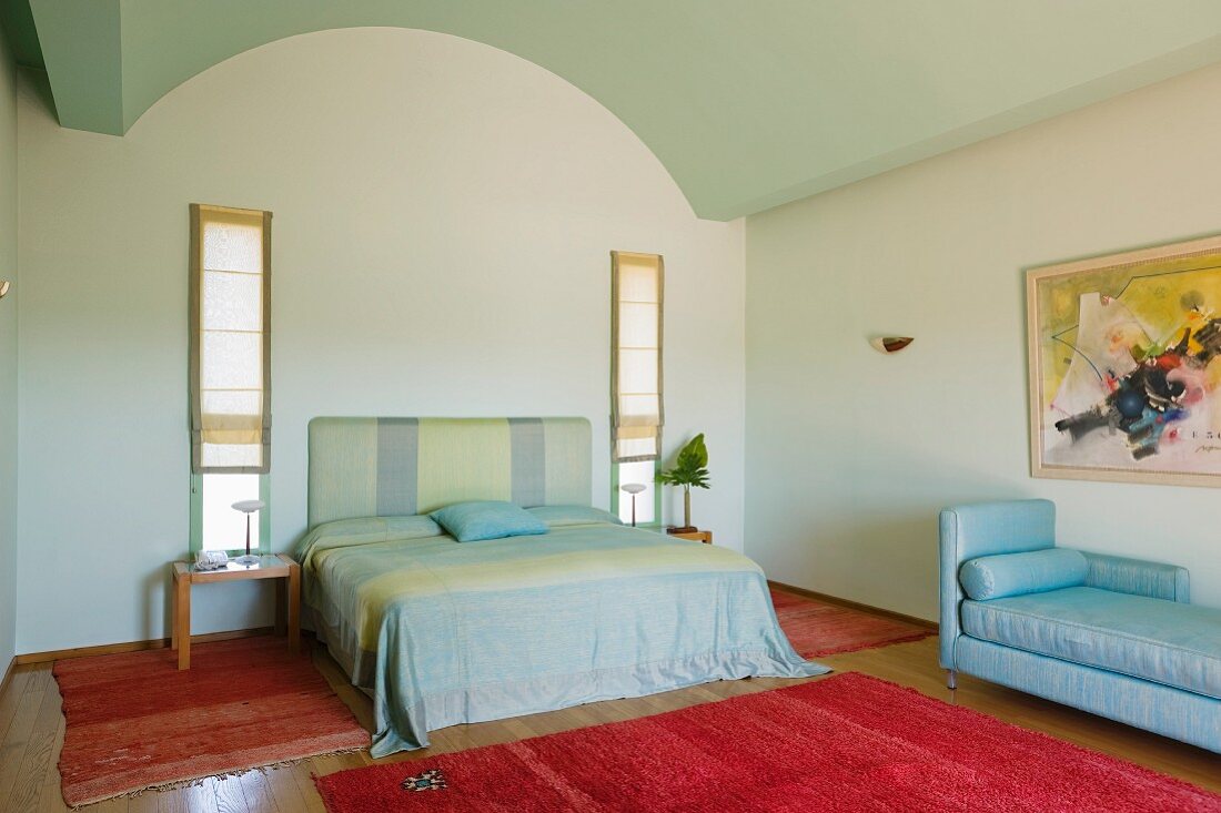 Modernes Doppelbett und handgeknüpfte Teppiche in minimalistischem Schlafzimmer
