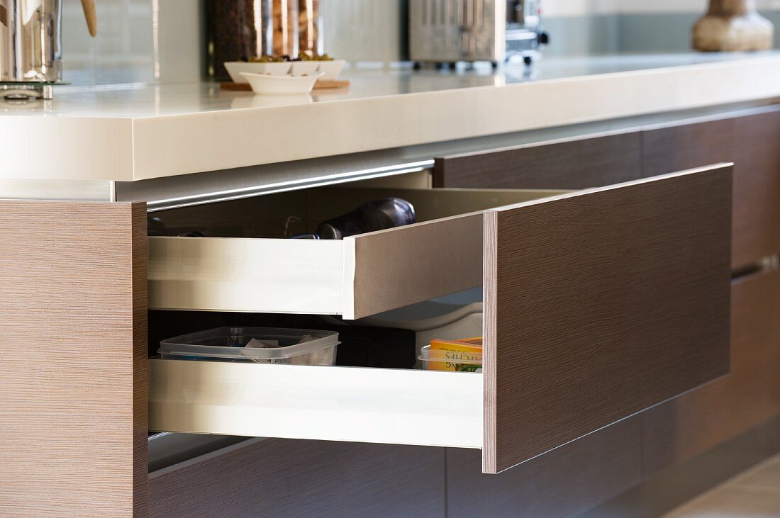 Geöffnete Schublade mit braunem Front in einer Kücheninsel integriert