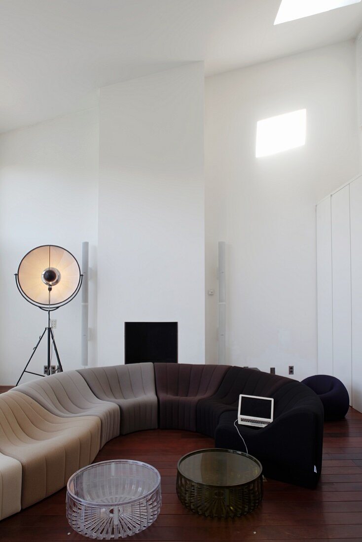 Moderne Sofakombination in Farbabstufungen im Wohnzimmer mit hoher Dachschräge und dunklem Dielenboden