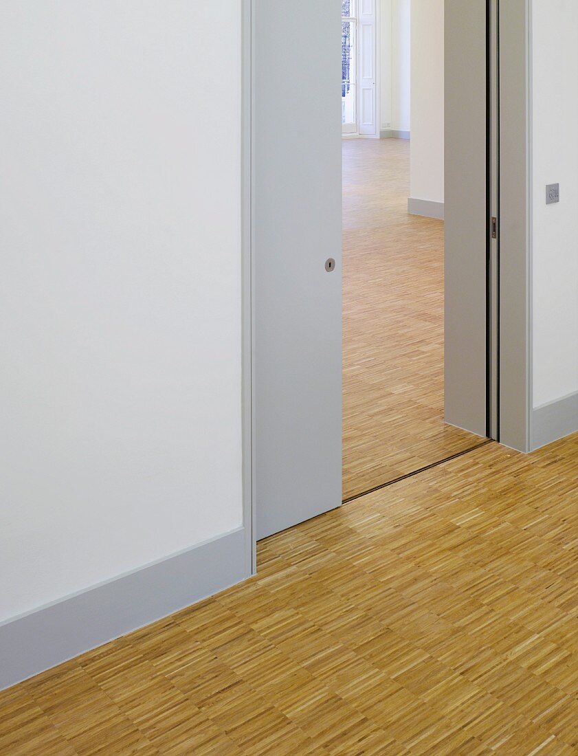 Räume mit durchgängig verlegtem Industrieparkett und Blick durch offene Schiebetür (Goethe Institut, London)
