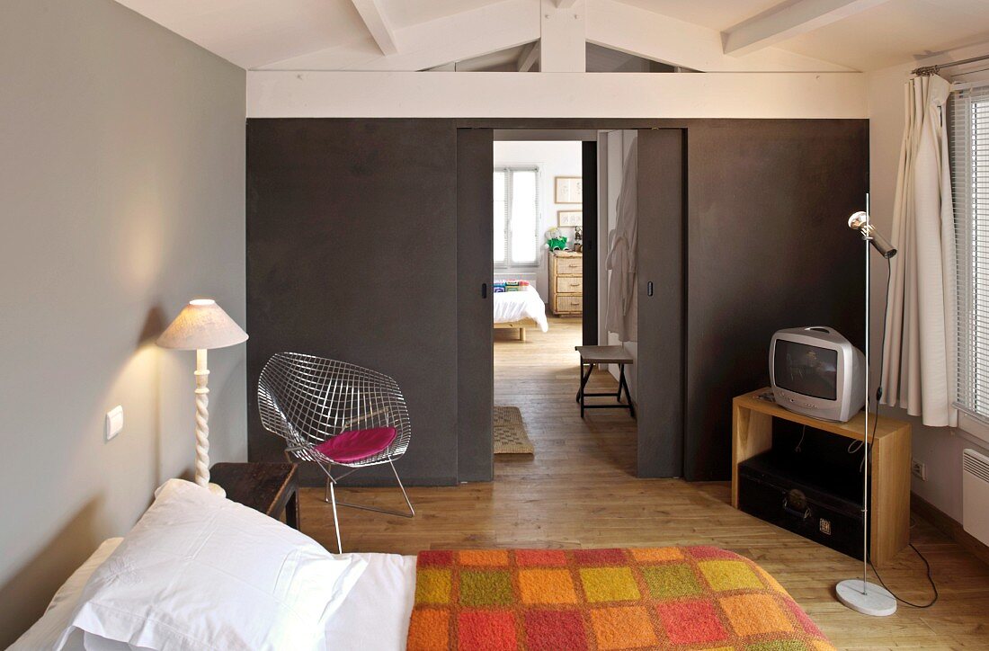 Modernes Schlafzimmer mit grau getönten Wänden und Klassiker Stuhl in Zimmerecke