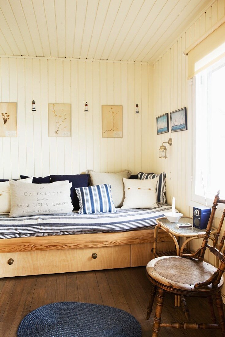 Schlafsofa in hellem Holzraum mit weiss-blau gemusterten Textilien
