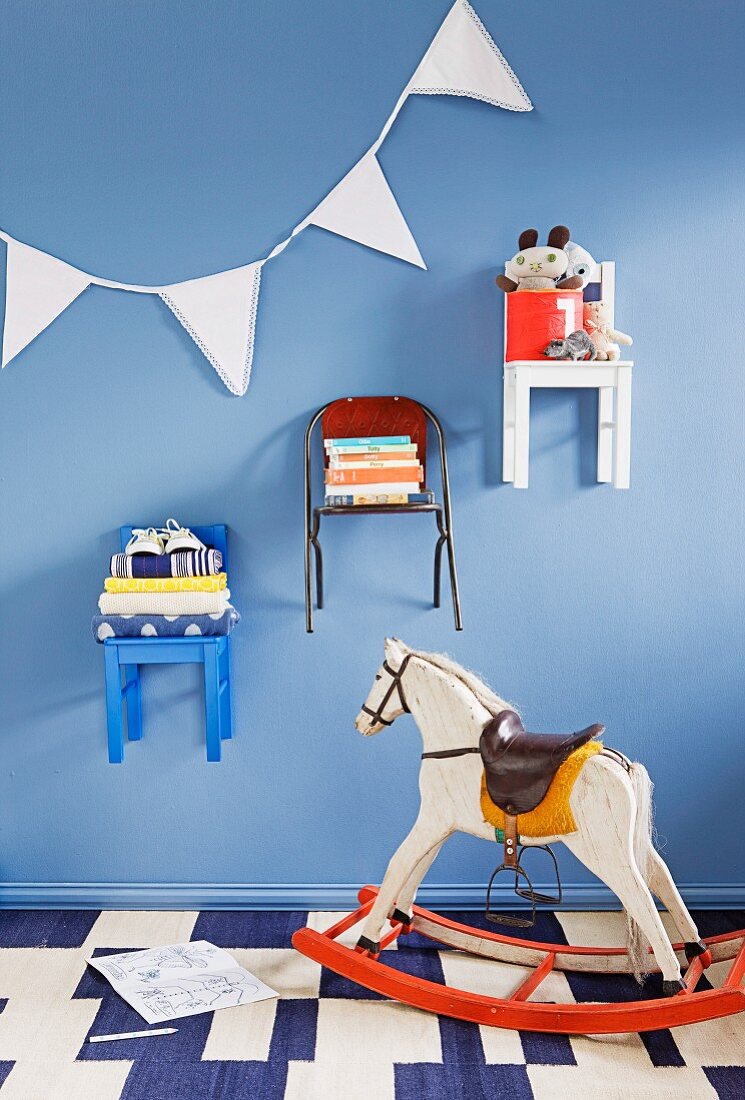 Children's chairs hung on wall and used as shelves