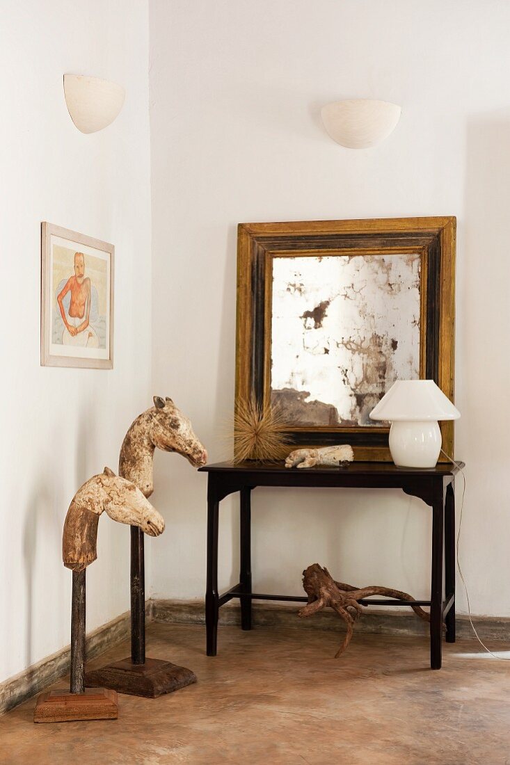 Tierfiguren neben Beistelltisch mit aufgestelltem Spiegel in moderner Wohnzimmerecke