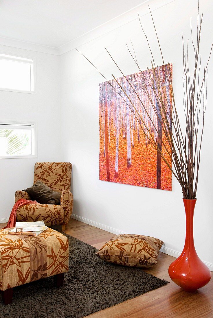 Interior in warm, earthy shades - bamboo-leaf pattern on beige upholstery next to brick red vase