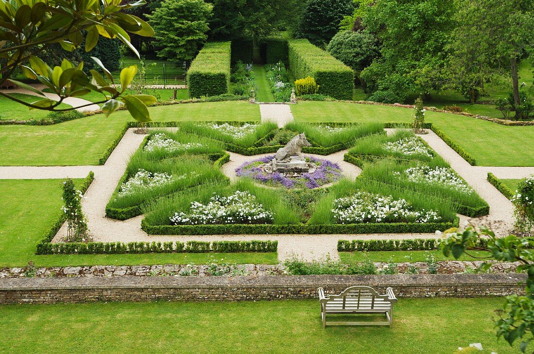 View down onto stately gardens with topiary hedges and geometric beds