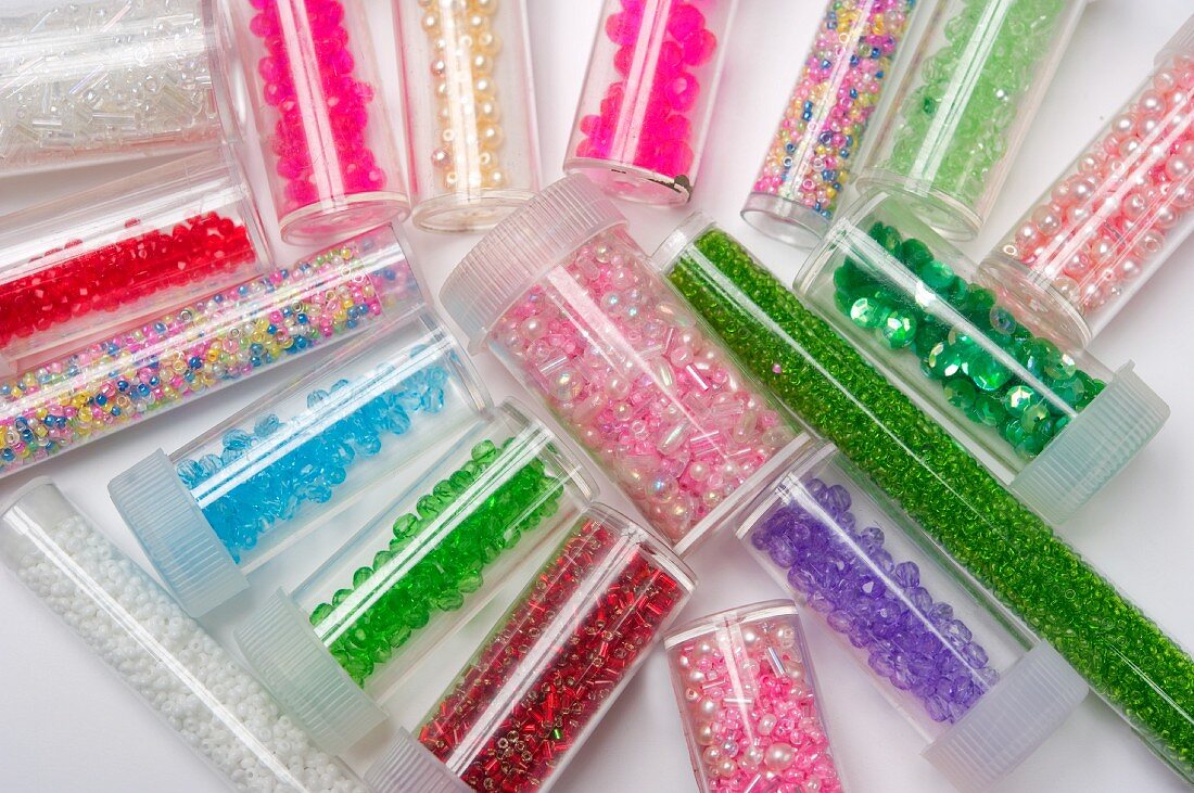 Assorted decorative beads and sequins in plastic tubes
