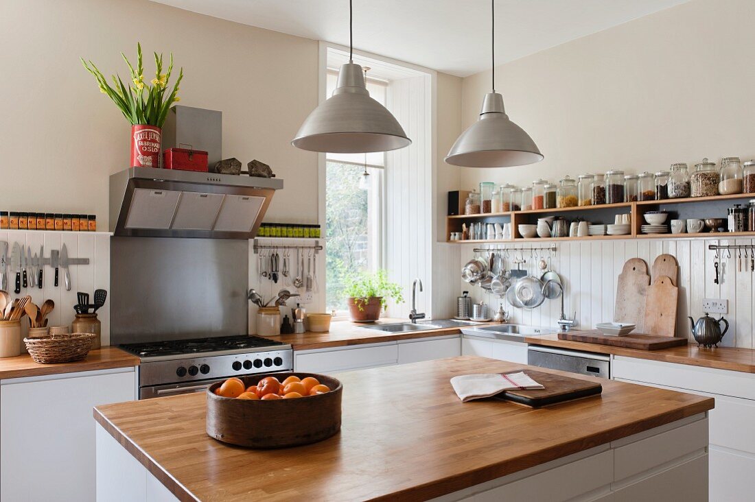 Spacious kitchen with open shelving and solid oak work surfaces. The pendant lights and units are both by Ikea