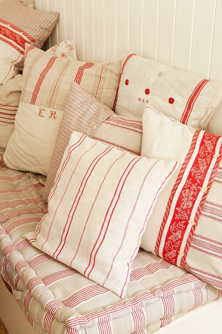 A variety of vintage white, pink and red striped and monogrammed cushion covers by Starched and Crumpled.