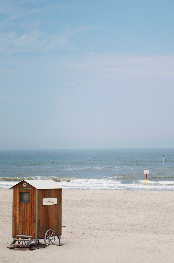 Wooden changing room on a lonely stretch of sandy beach