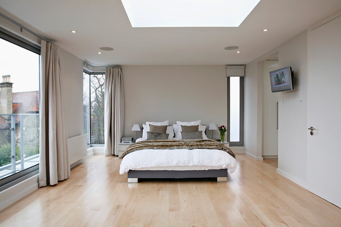 Elegantes Schlafzimmer im Designerstil mit raumhohen Fenstern