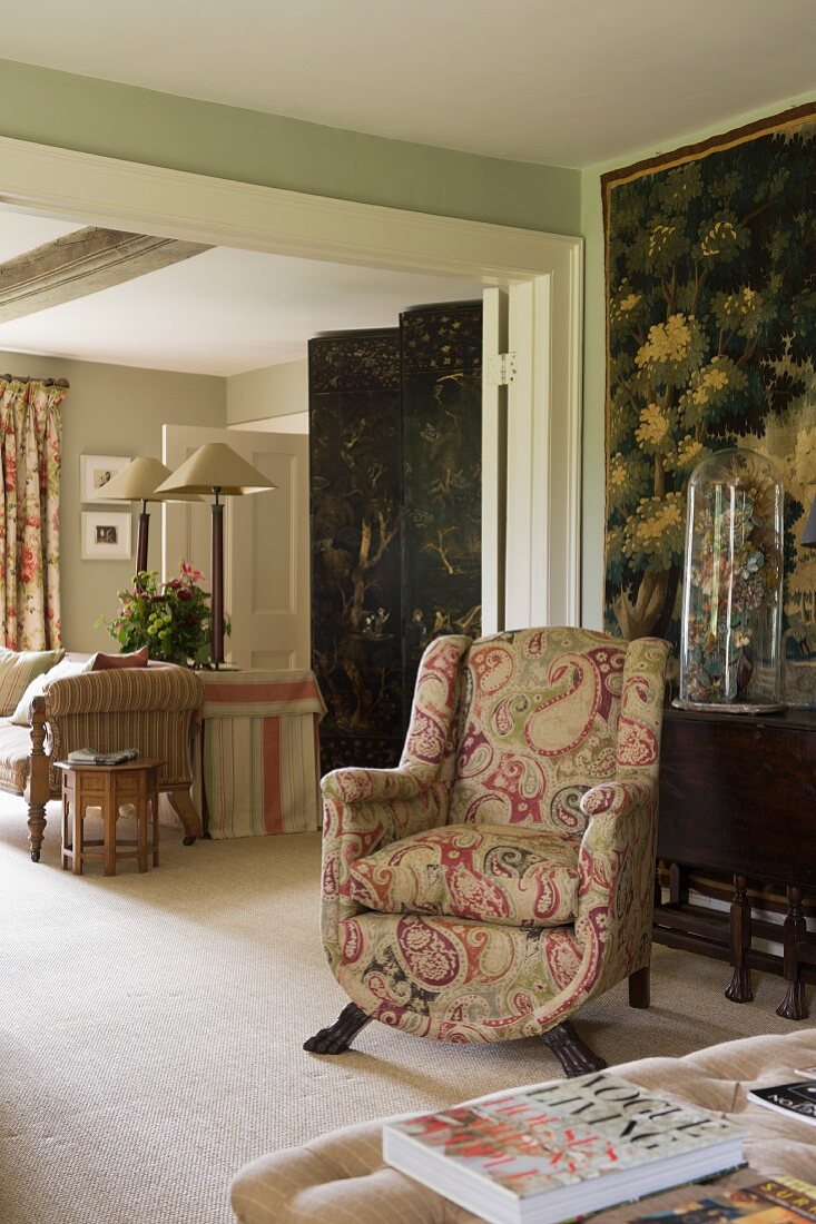 Paisley upholstered armchair with 18th century lacquer screen in home of fabric designer Richard Smith