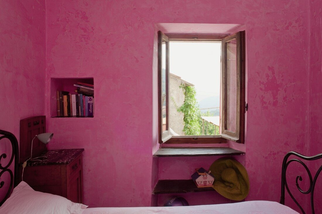 Pinkfarbenes Schlafzimmer mit quadratischer Wandnische und geöffnetem Fenster