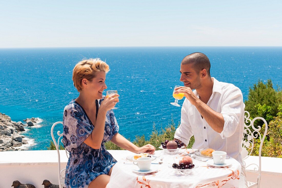 Couple breakfasting on a terrace with an ocean view