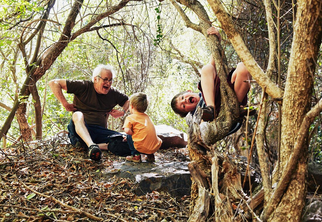 Grandfather and grandsons playing in the forest