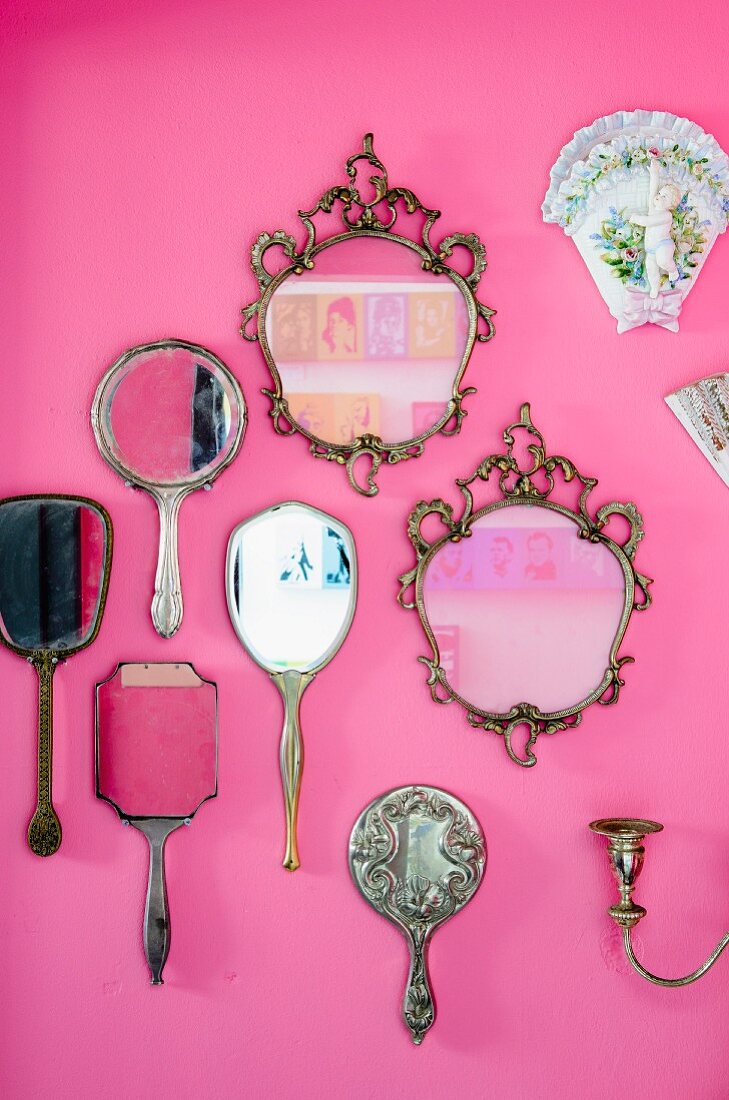 Vintage Spiegel- und Handspiegelsammlung auf pinkfarbener Wand