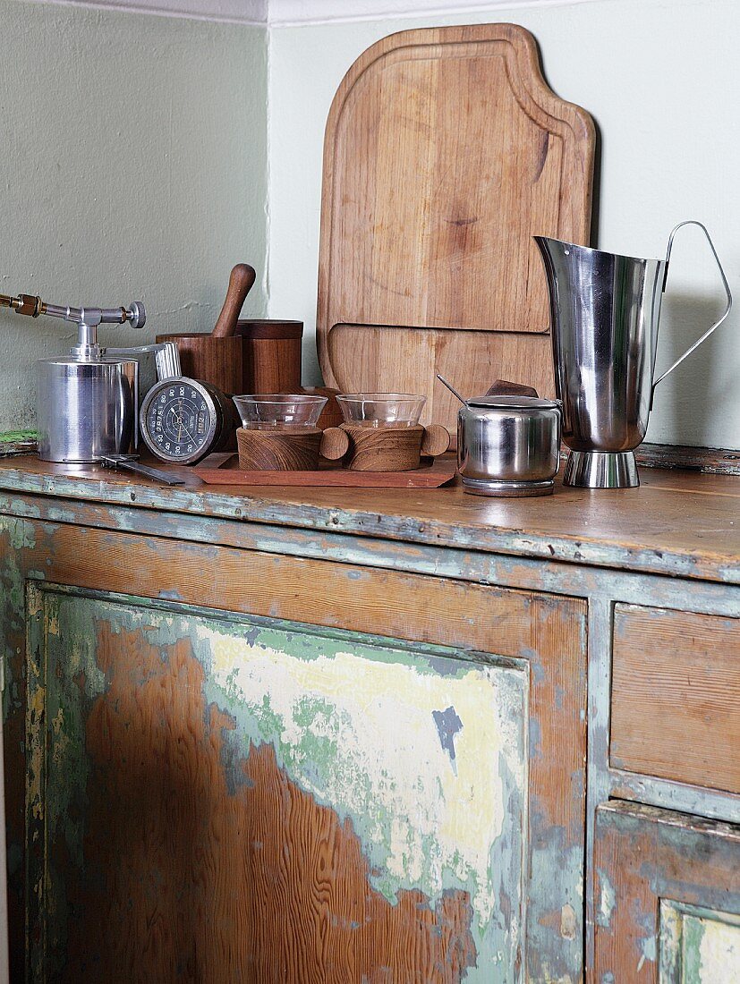 Hochwertige Küchenutensilien auf Vintage Küchenzeile mit renovierbedürftigem Unterschrank