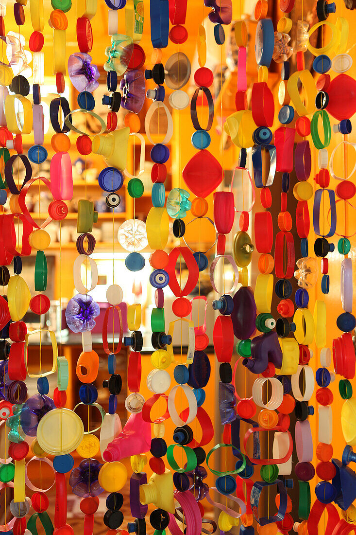 Colourful string curtain threaded with parts of plastic bottles