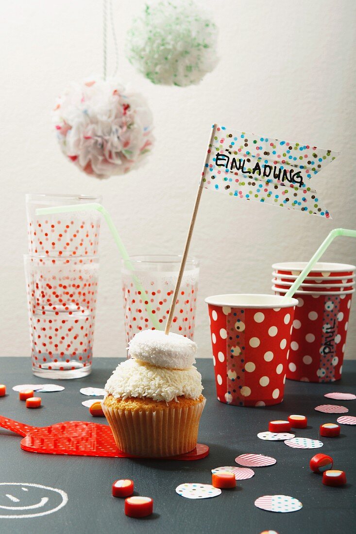 Cupcake mit Masking-Tape-Fähnchen, Pappbecher, Gläser und Partydeko