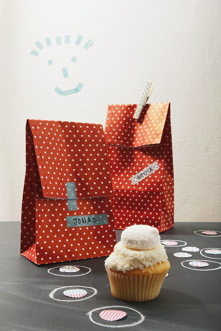 Party loot bags with name tags and one cupcake