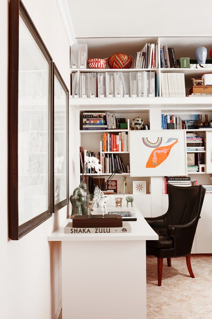Corner office area - black leather armchair at white desk and fitted shelving