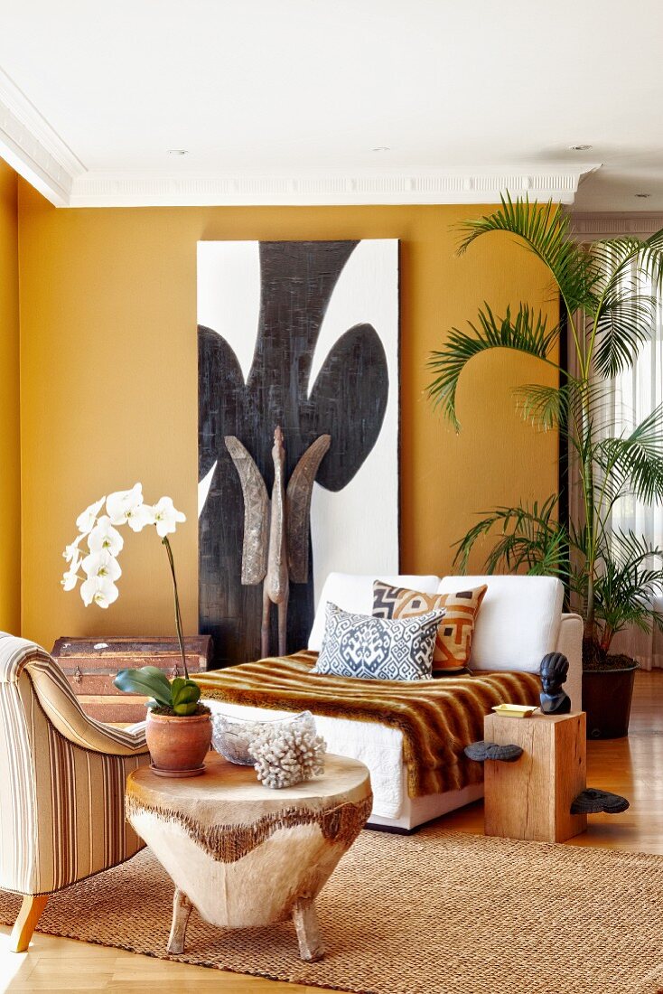 Corner of dark ochre living room with colonial-style lounge chairs