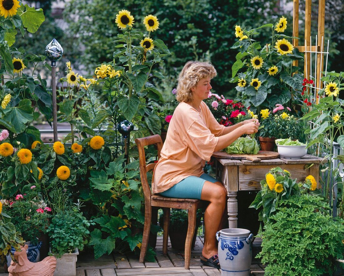 Frau mit Salat auf sommerlicher Terrasse